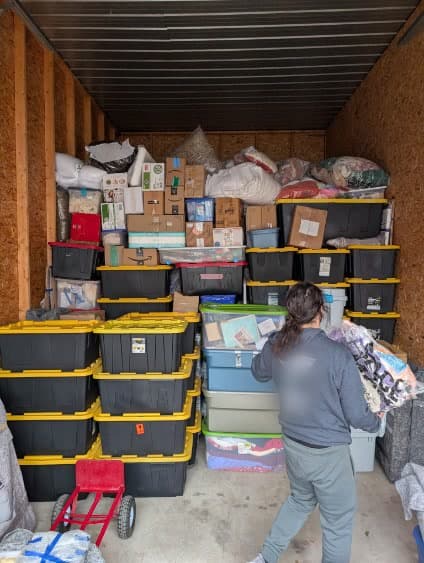 The wall goes up — totes squared, stacked tight, nothing wasted.