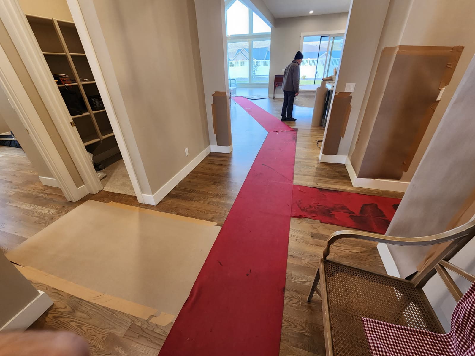 Red floor runner and paper protection through a hallway with wrapped door jambs